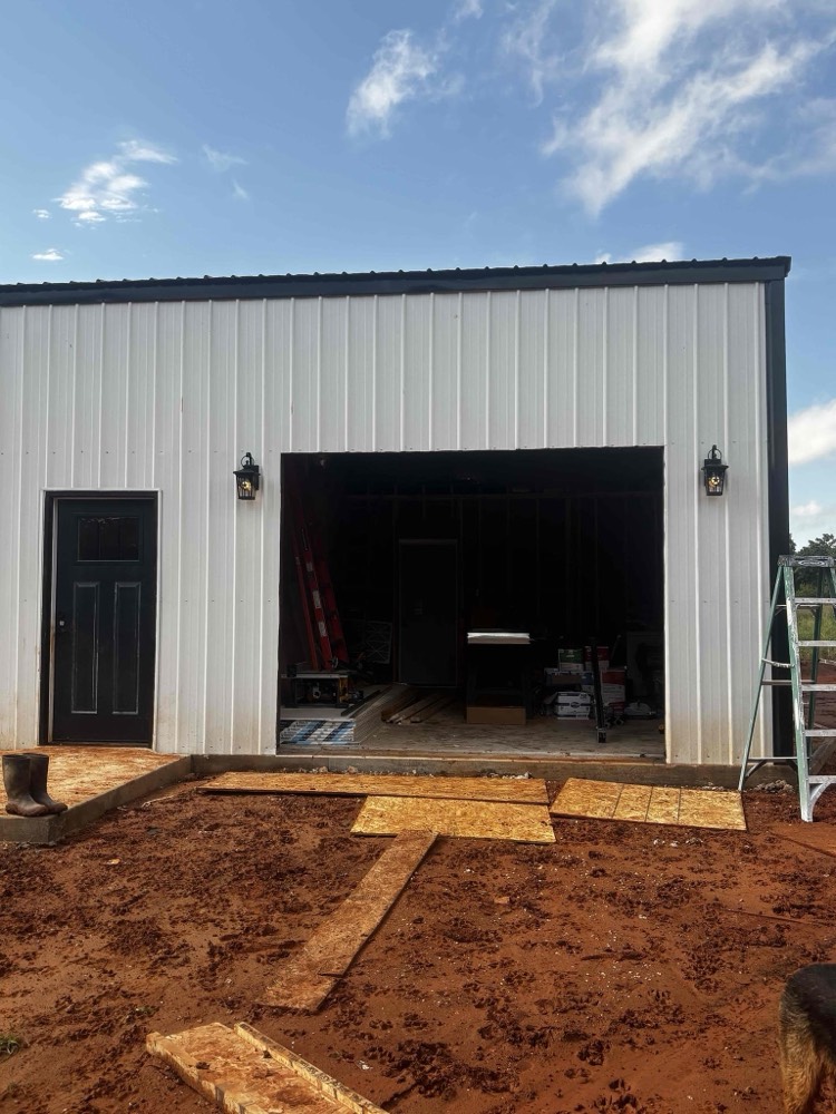 Finished black garage door installation on metal-framed garage