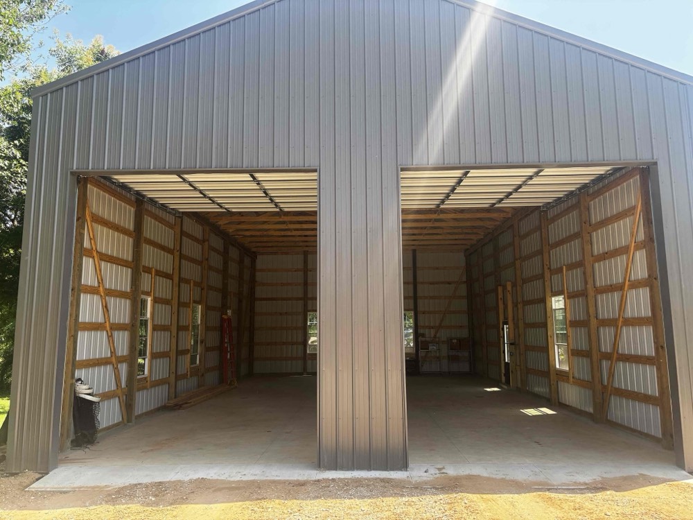 Two custom wood-frame garage doors open inside metal building structure