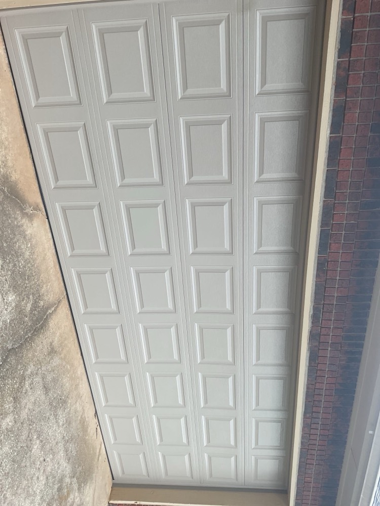 White multi-panel garage door newly installed on residential opening