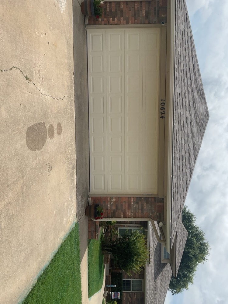 Newly installed white garage door on brick home