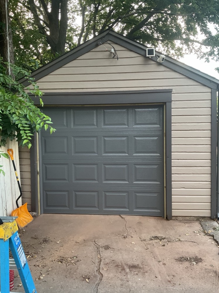 Dark gray garage door on beige siding residential home in Oklahoma City