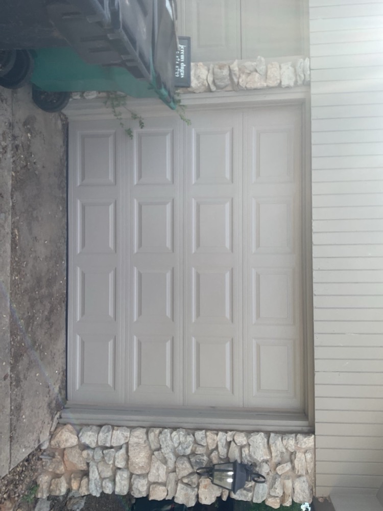 White 9-panel garage door installation with stone foundation in Oklahoma City