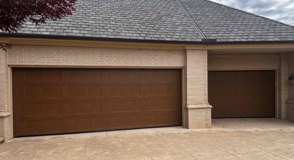 Two brown wood-grain garage doors on residential home exterior
