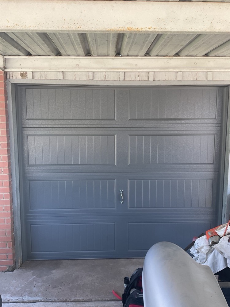 Finished gray steel raised-panel garage door installation