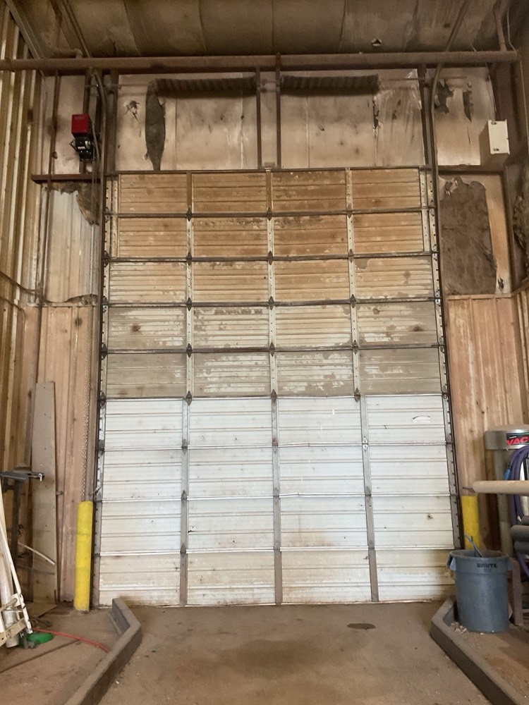 Installed multi-panel garage door with white and wood tones