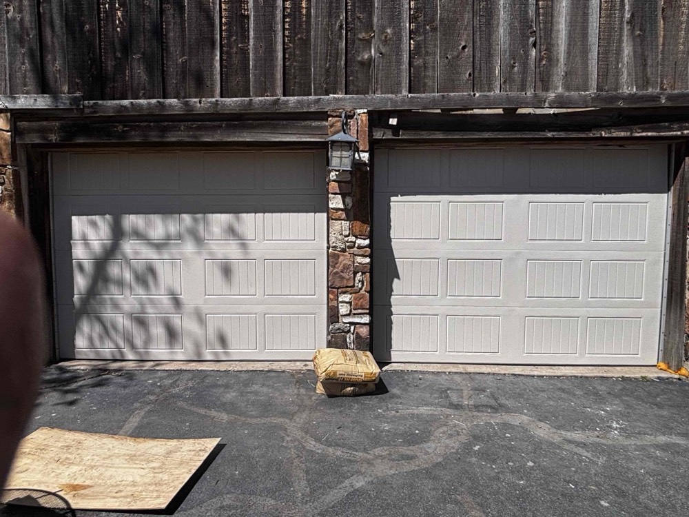 Two newly installed white garage doors on residential home