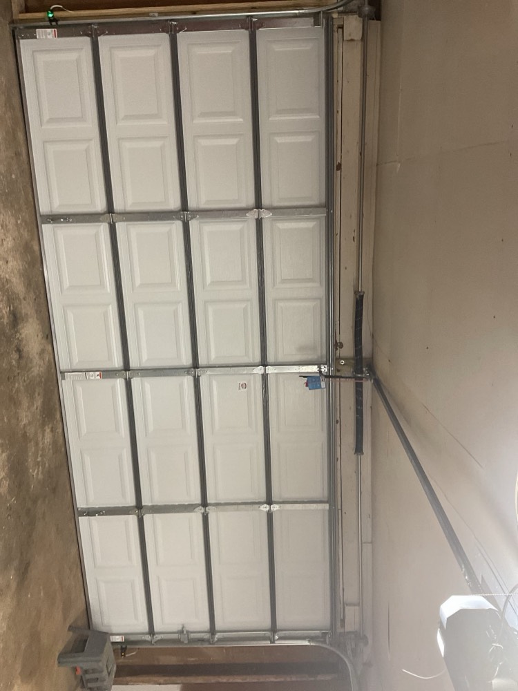 White sectional garage door panels mounted in frame during installation in Oklahoma City