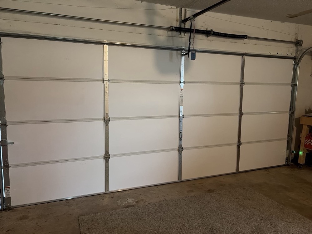 White garage door with visible frame and hardware installed.