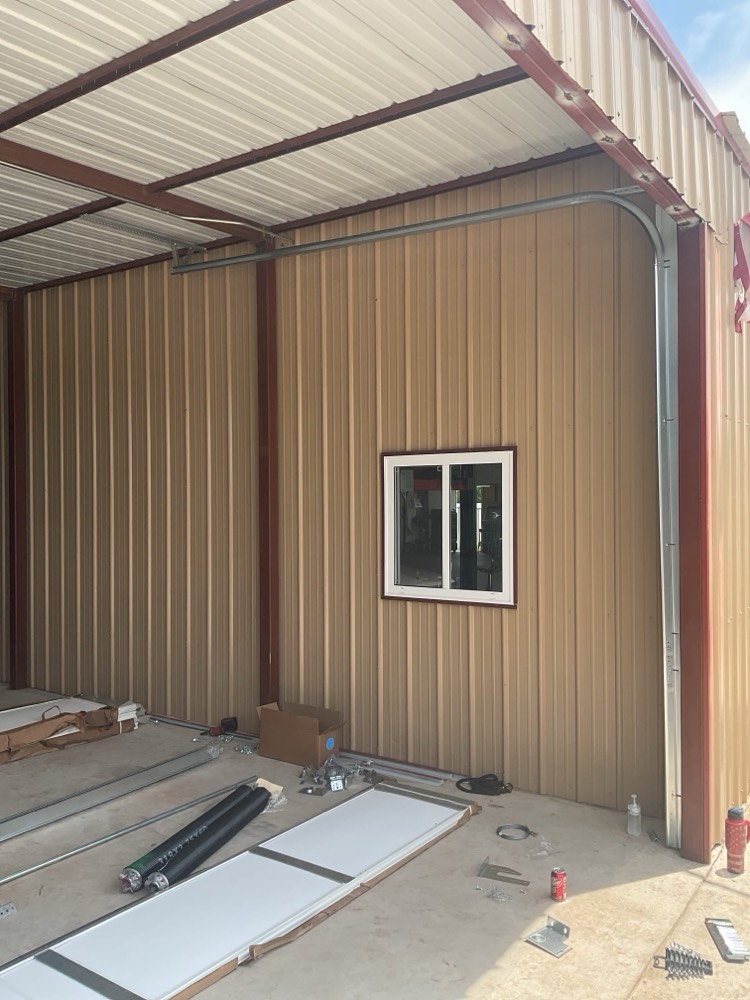 Newly installed two-car garage door with metal frame and window trim