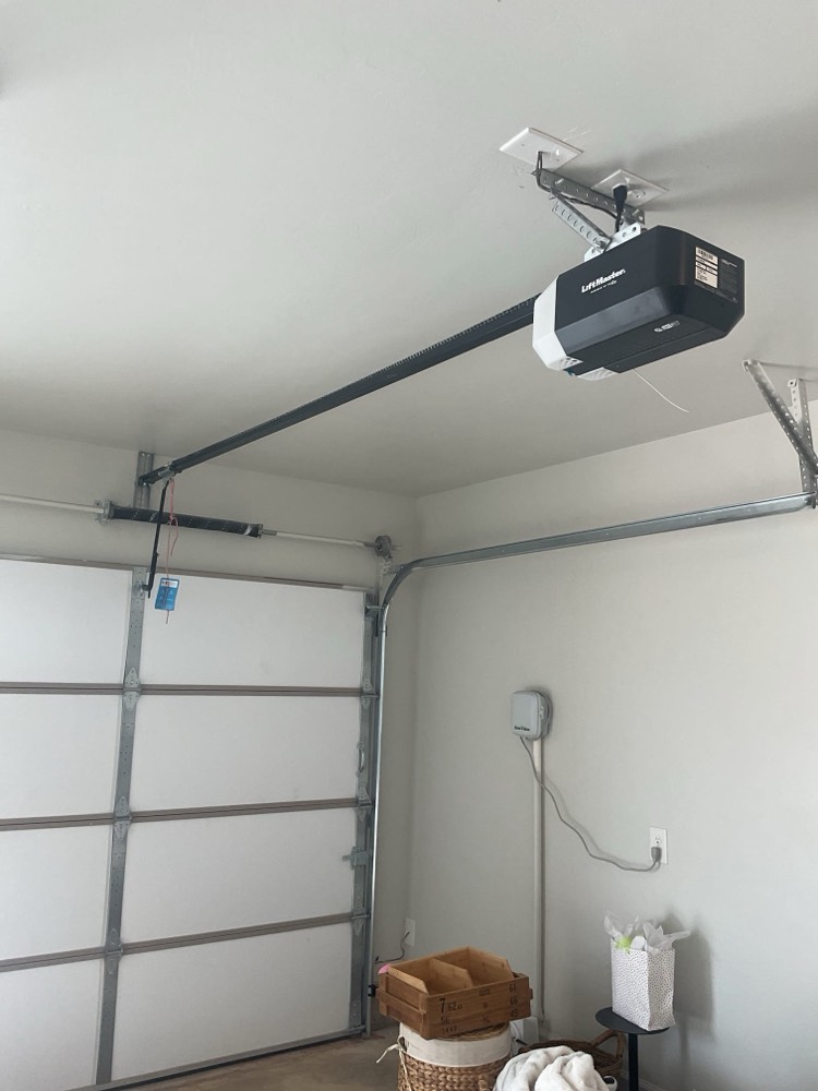 Professionally installed garage door opener motor and track system in residential garage.