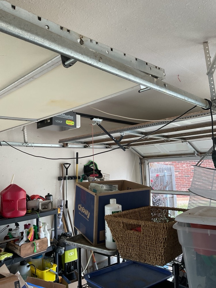 Fully installed garage door opener system mounted on ceiling