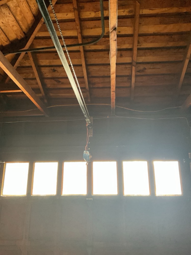 Installed garage door opener with rail and chain above door opening