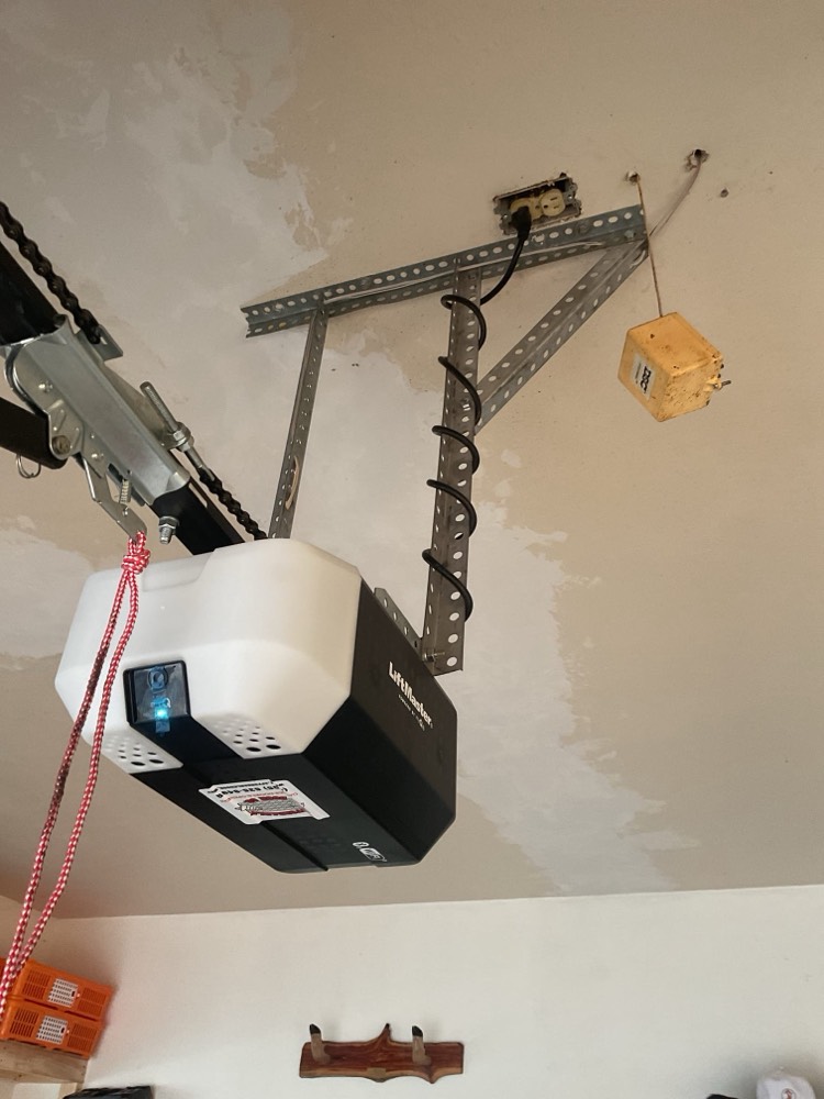 Installed garage door opener with ceiling mounting bracket and electrical connections