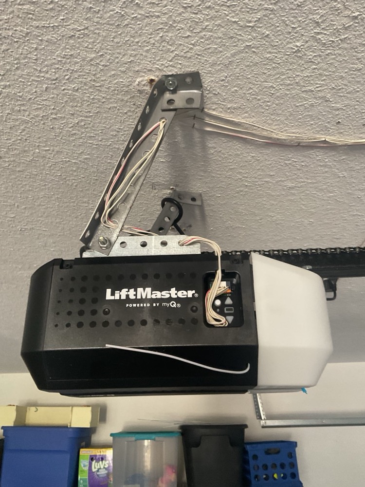 LiftMaster garage door opener mounted on garage ceiling with wiring