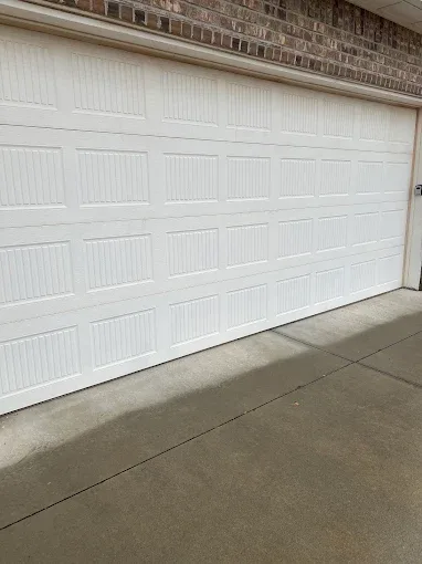 White raised panel garage door on brick home by Affordable Door Co Oklahoma City