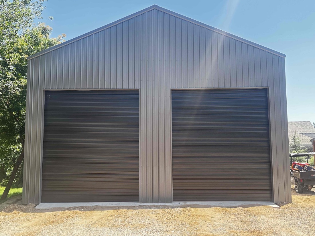 Two dark metal garage doors installed on commercial building in Crescent