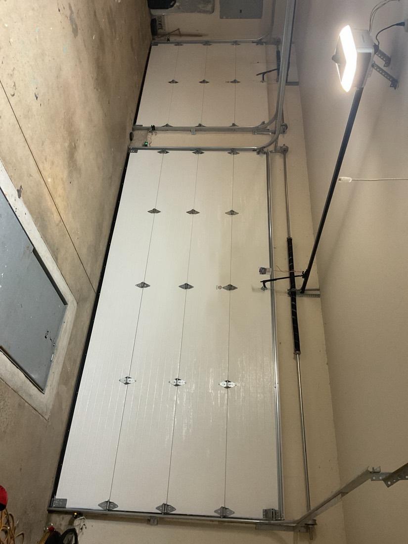 White garage door panels with installed track and hardware inside garage