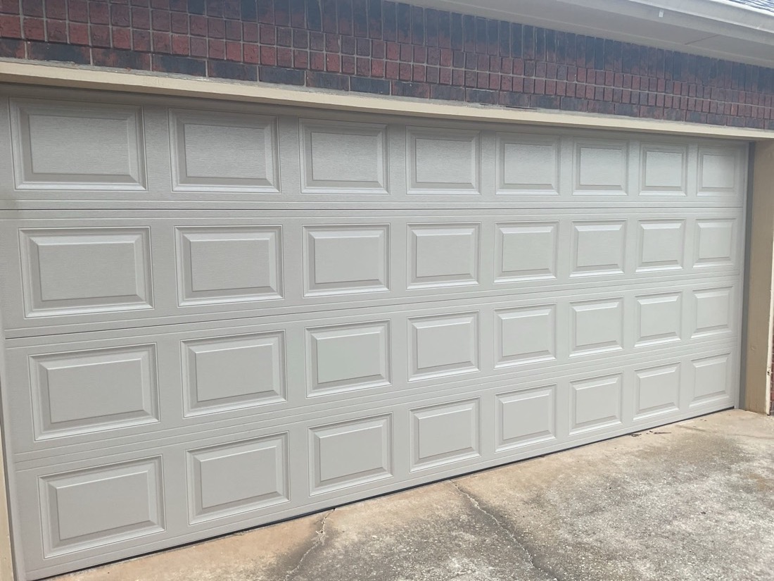 White multi-panel garage door newly installed on residential opening
