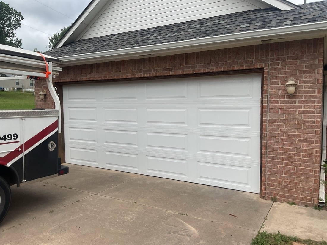 Finished white sectional garage door installation exterior view