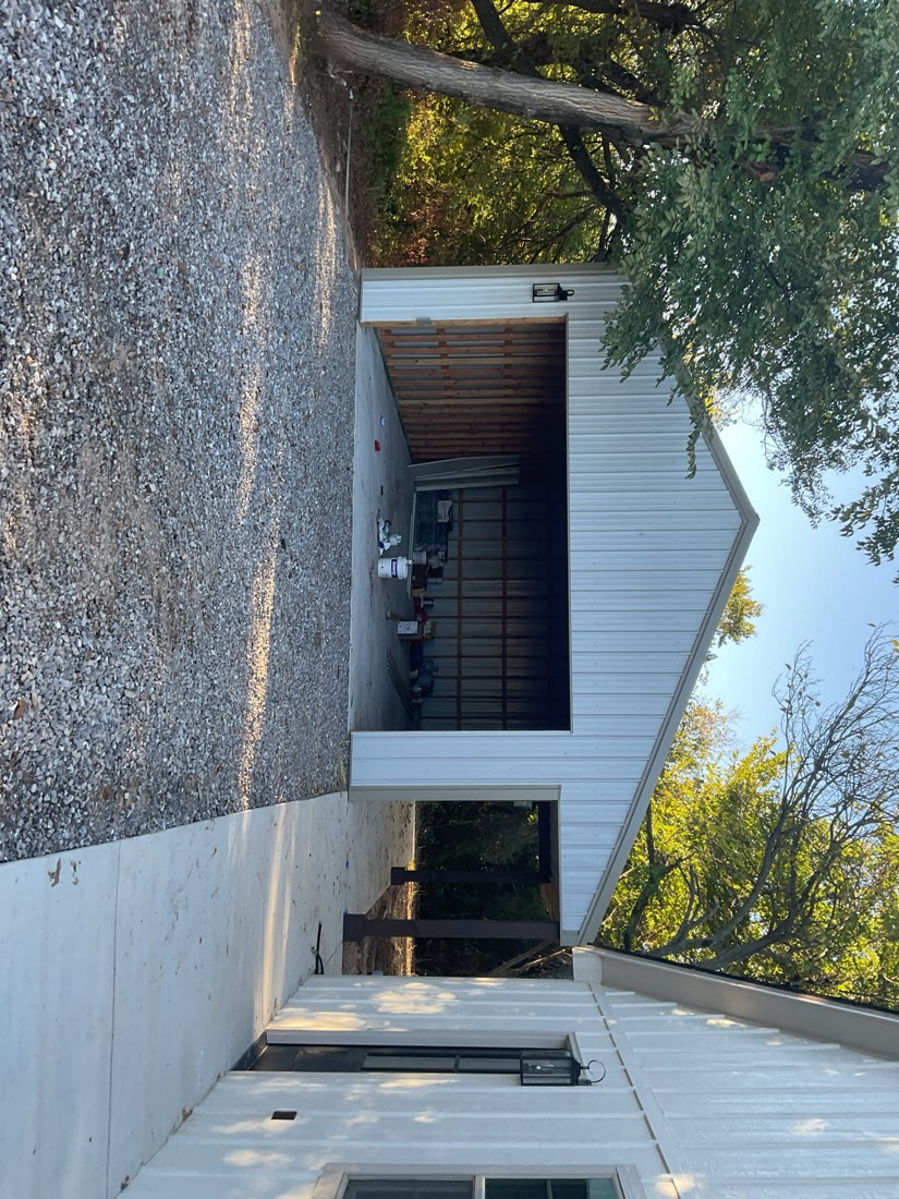 Installed dark garage door in open bay with surrounding white trim