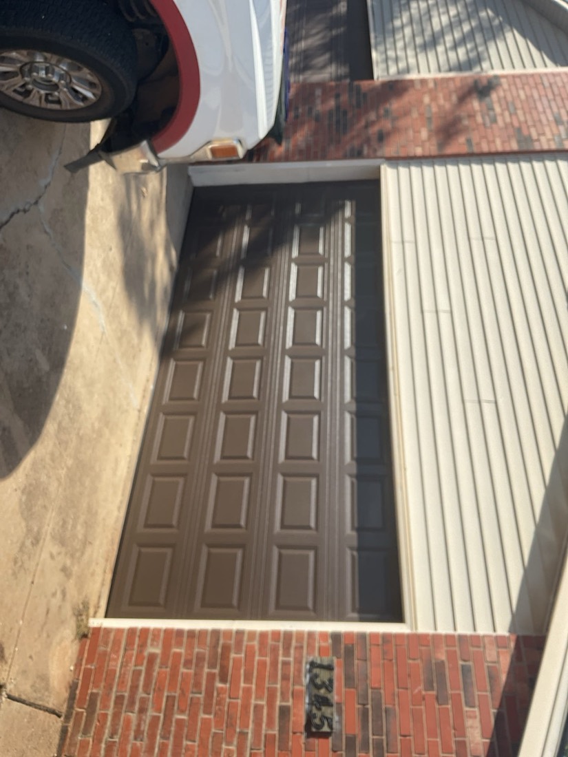 Installed brown raised-panel garage door on residential home