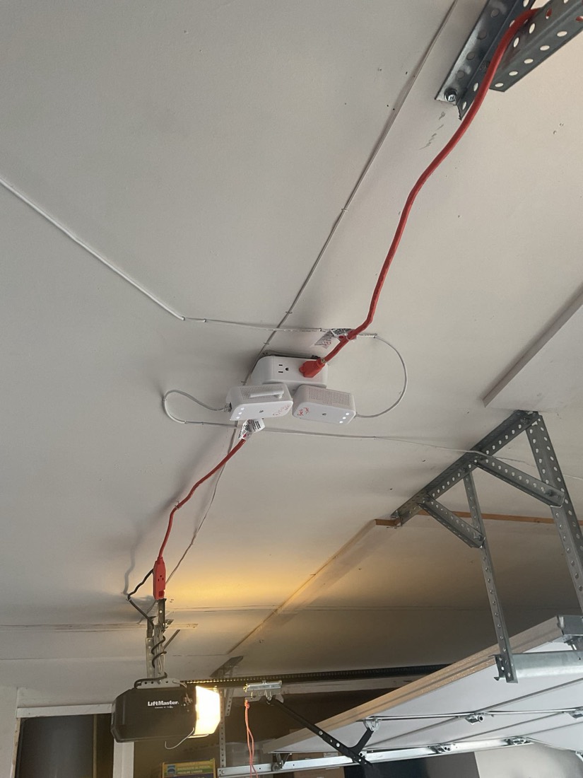 Overhead garage door opener motor with wiring and mounting brackets.
