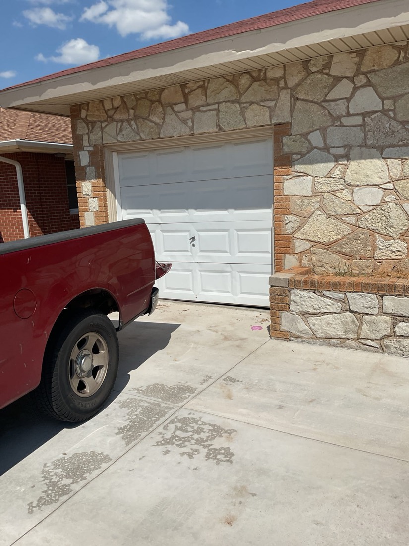 Newly installed white garage door on brick and stone home exterior.
