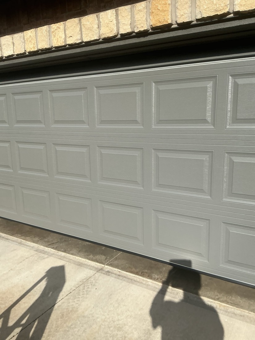 Finished white garage door installation with visible panel details