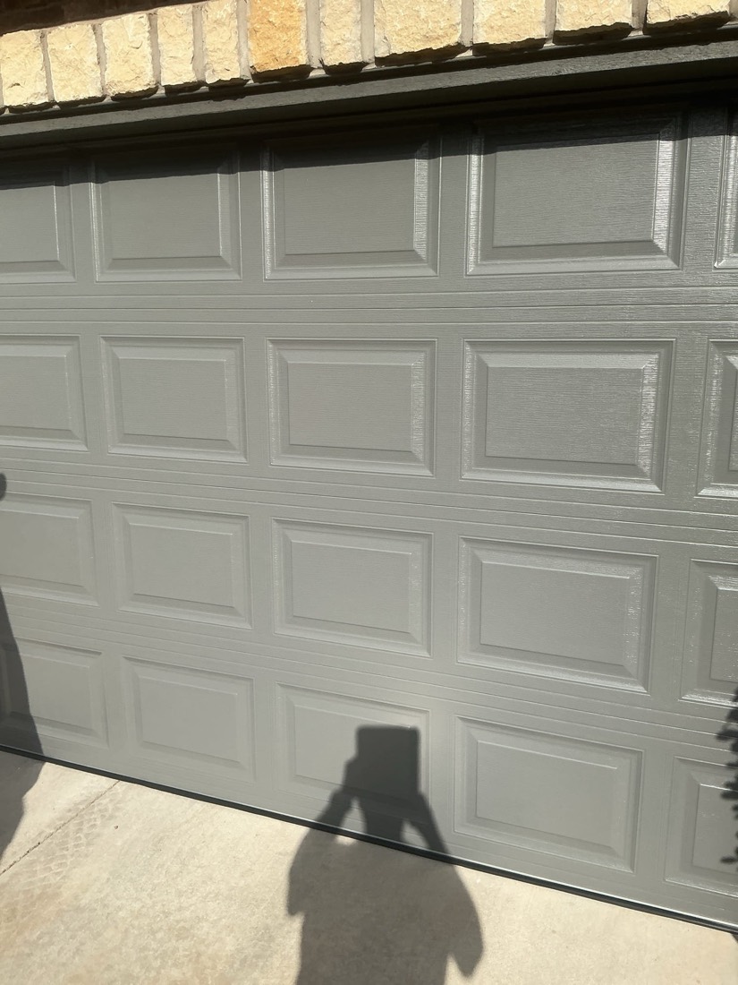 White panel garage door installed on brick home exterior