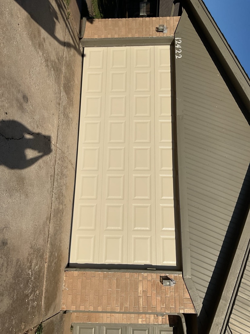 Installed cream panel garage door viewed from exterior driveway