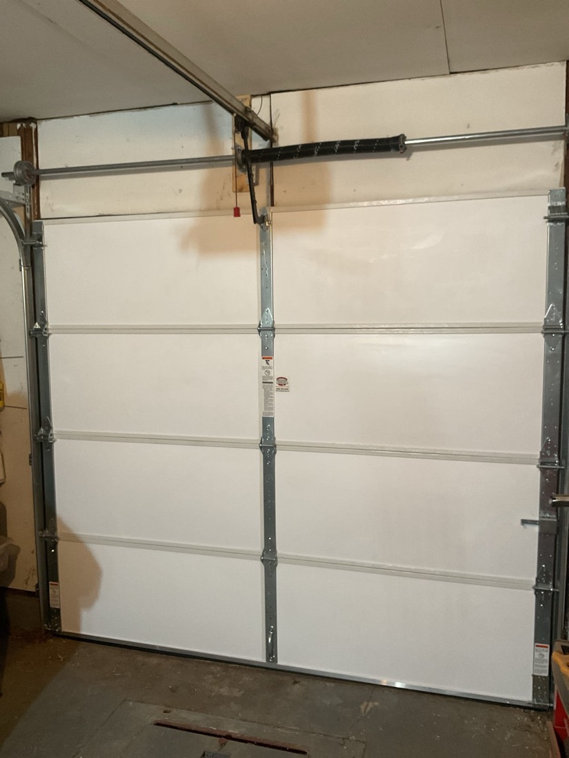White nine-panel garage door with metal frame and hardware installed