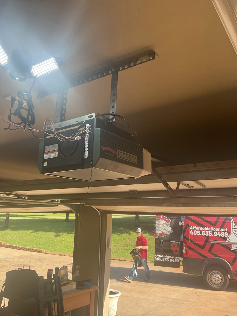 Installed garage door opener with LED work lights and structural support mounted to garage ceiling.