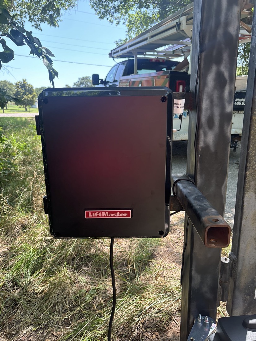 LiftMaster control box mounted on metal gate frame with power connection.