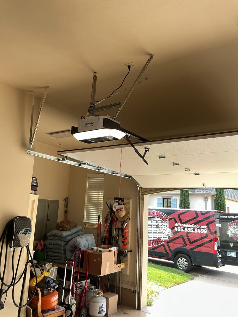 Installed garage door opener with integrated LED light fixture mounted to ceiling.