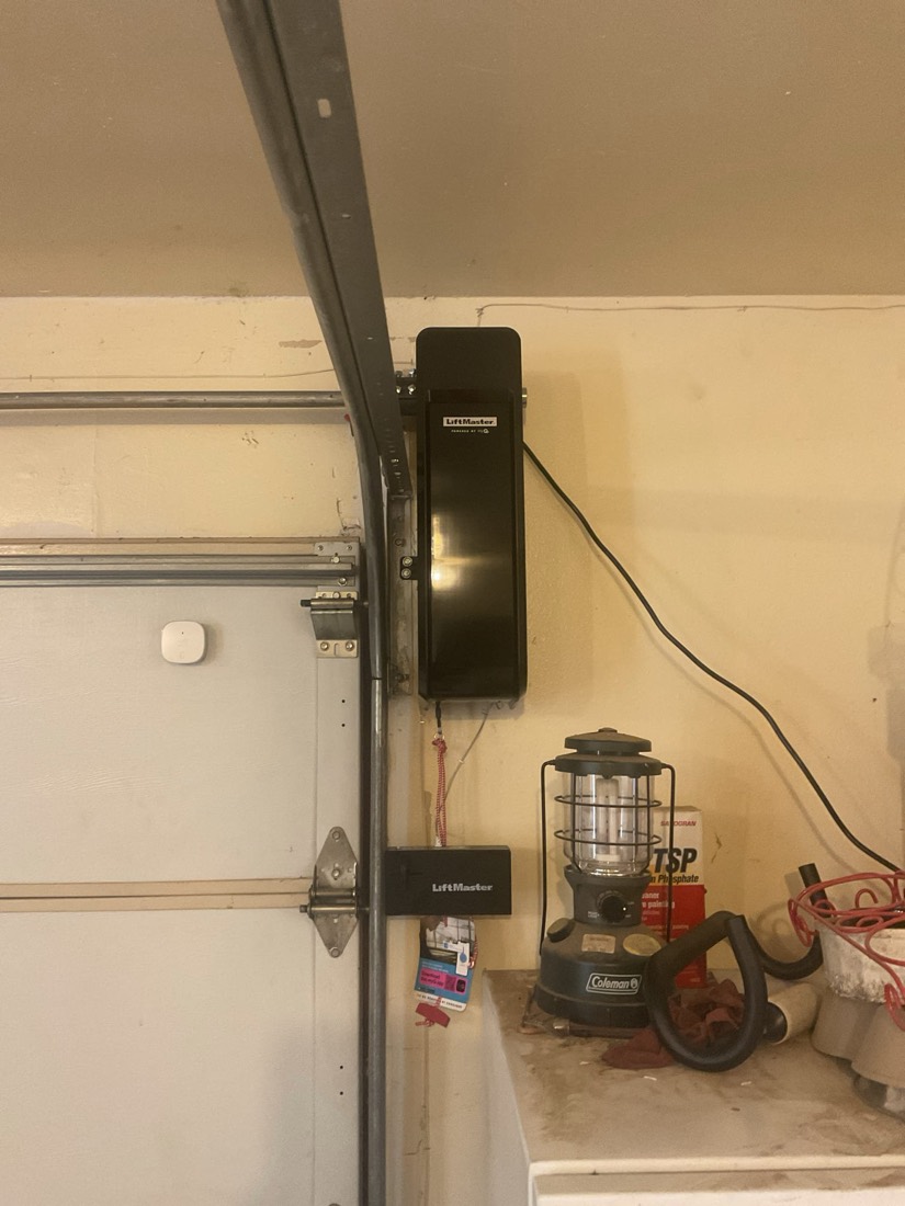 Installed garage door opener with motor and wall-mounted control unit