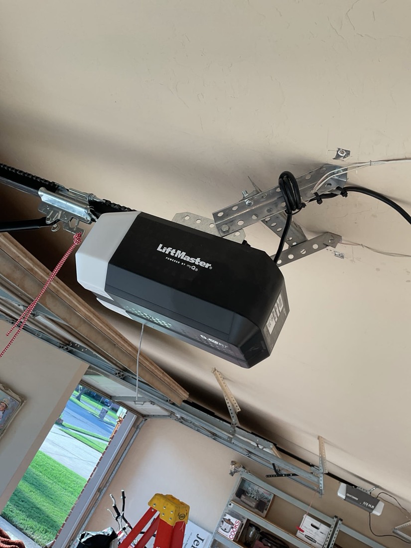 LiftMaster garage door opener mounted to garage ceiling header with bracket and cable