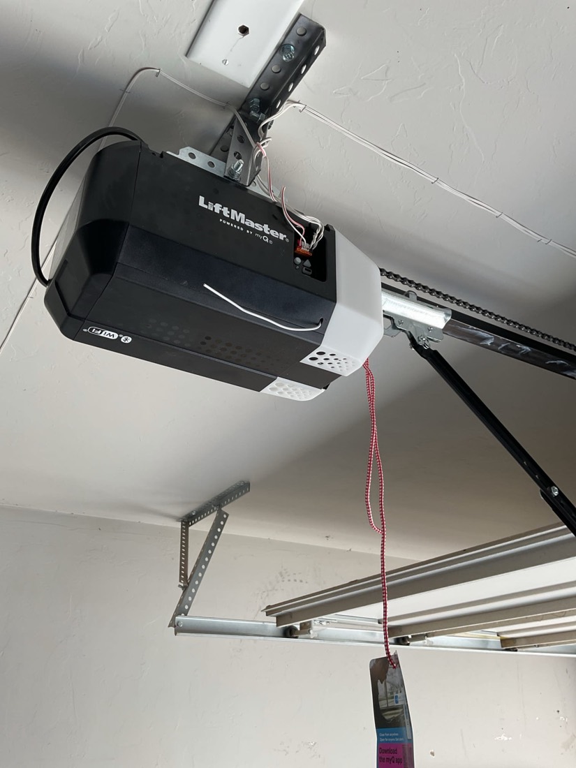 LiftMaster garage door opener installed on ceiling with red control wire