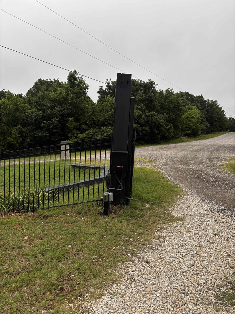 Installed automatic gate opener with black steel fence gate.