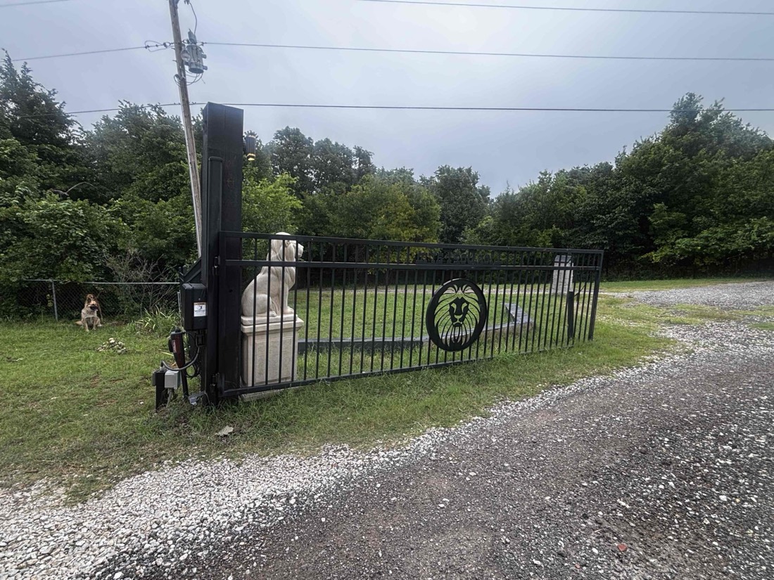 Black driveway gate with installed automatic opener system.
