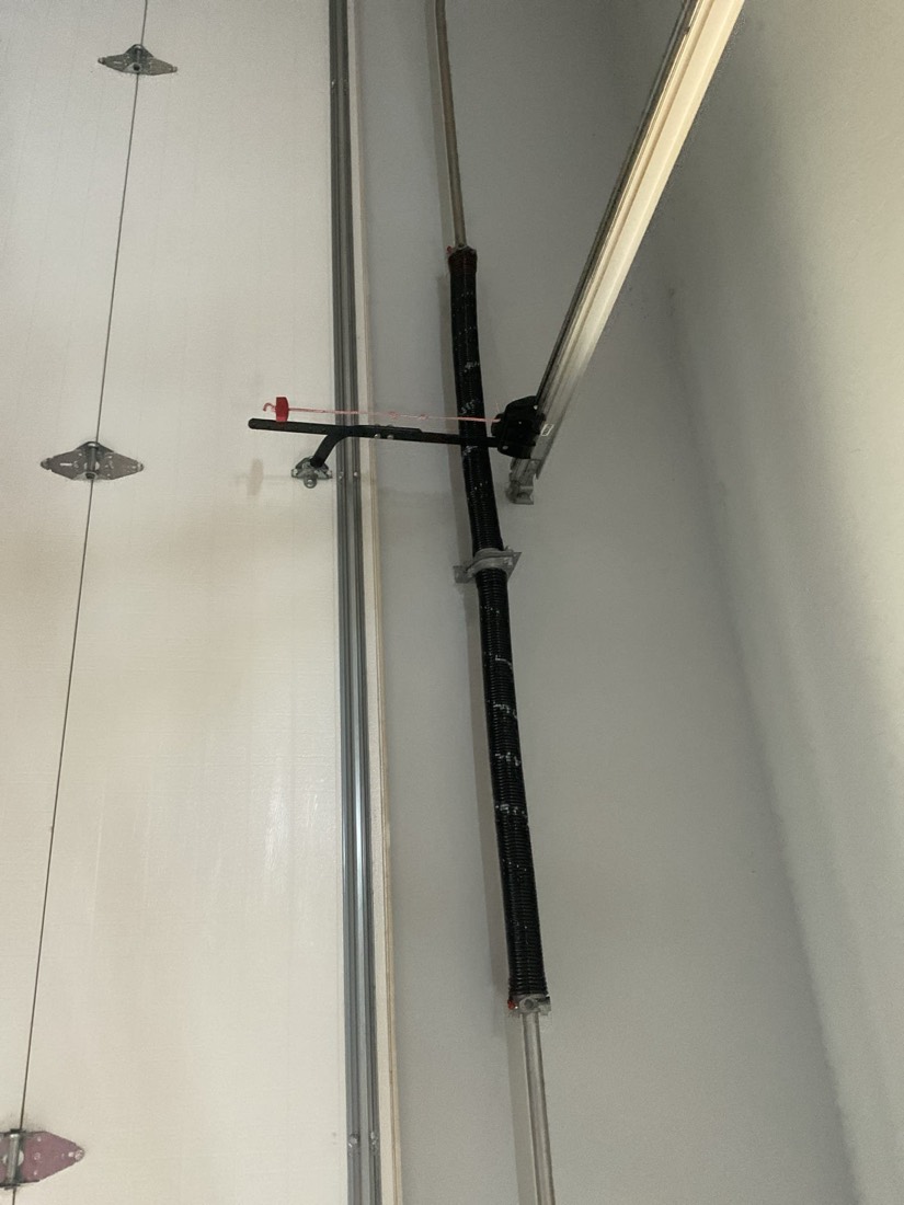 New garage door spring and hardware mounted on vertical track