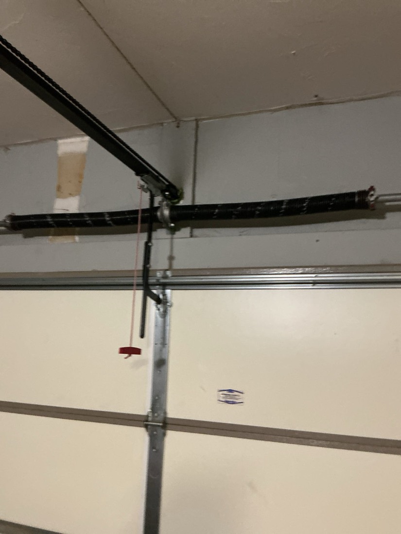 Garage door spring and pulley assembly on ceiling frame
