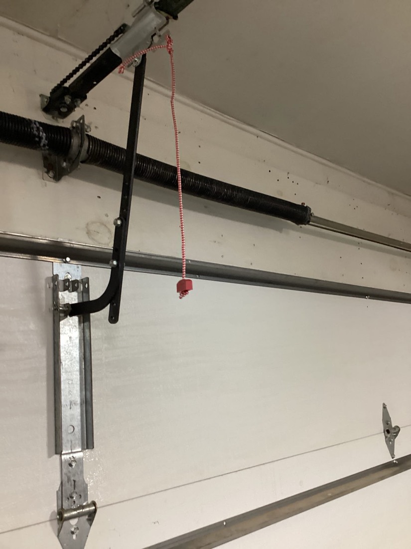Completed garage door spring repair with new springs and bracket.