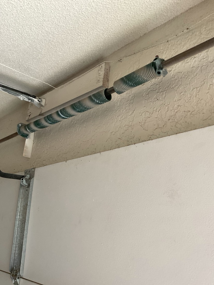 Twin garage door torsion springs mounted on shaft showing professional installation.