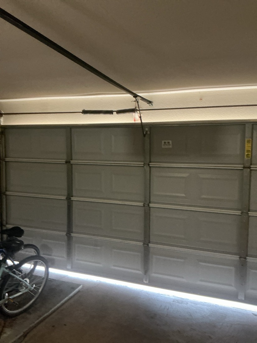 Gray aluminum garage door with newly installed spring assembly.