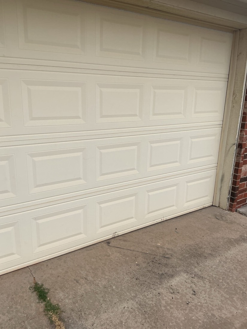 White nine-panel garage door installed on home exterior.