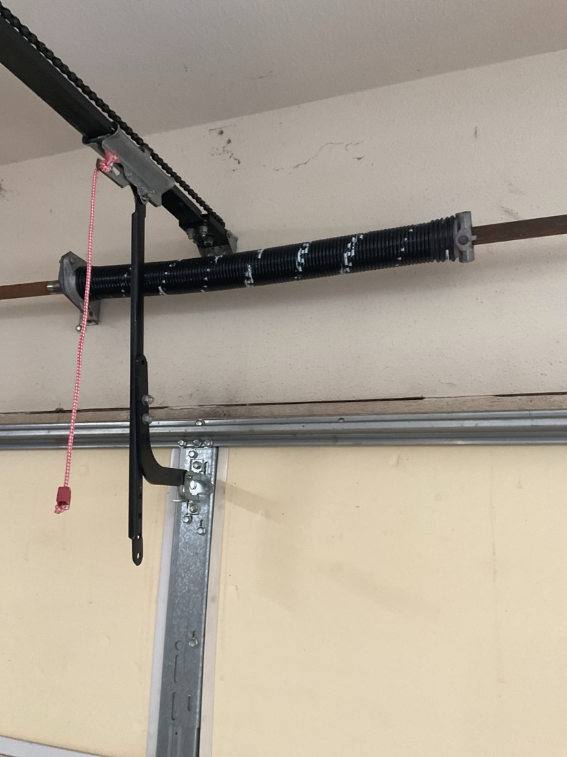 Installed garage door spring and bracket assembly