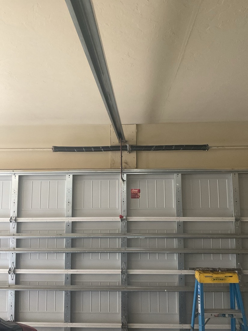 Garage door panels with visible frame and track components during repair work.