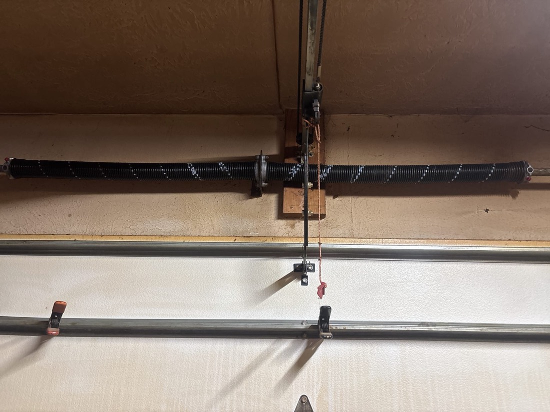 Garage door torsion spring and pulley assembly installed during spring repair service.