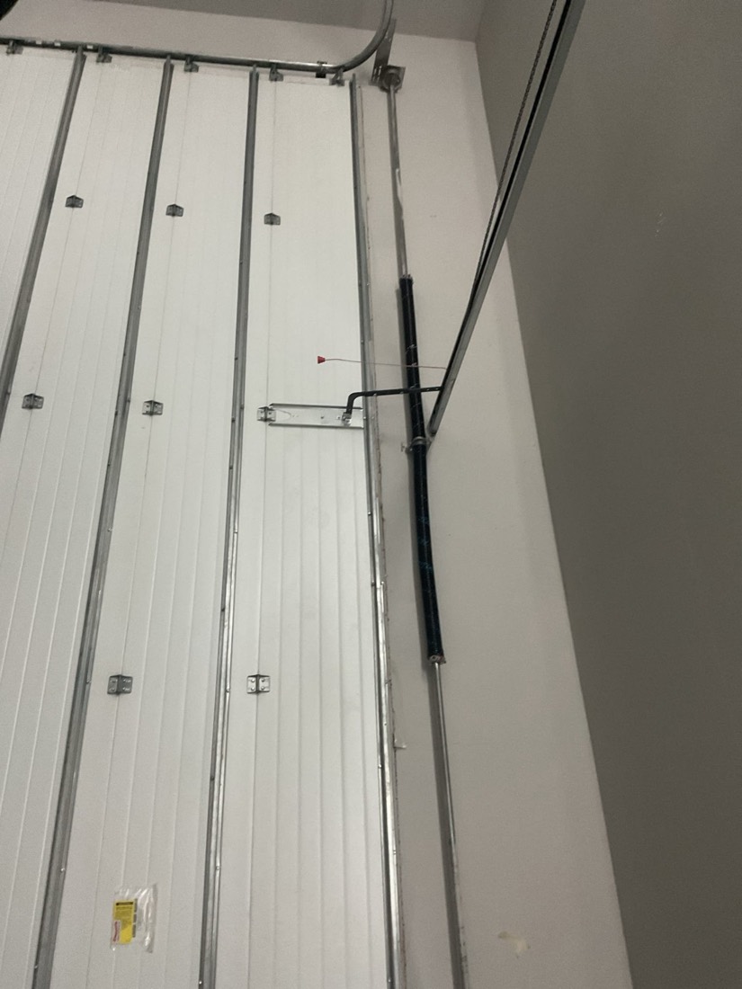 Garage door track, cable, and pulley system during spring repair