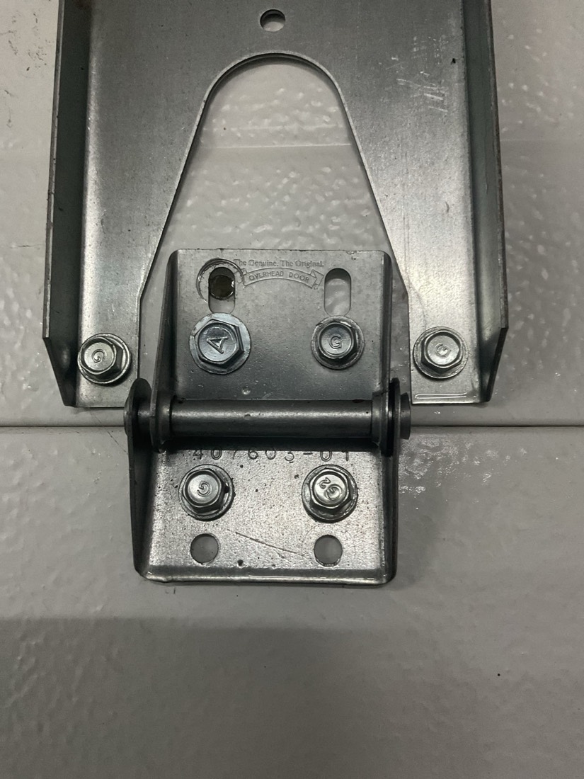 Garage door roller wheel and pulley assembly mounted on metal bracket